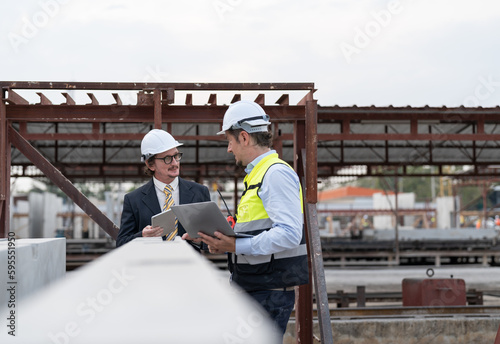 Businessman and male engineer discussing the quality of steel bar in concrete for making precast concrete wall at construction site.