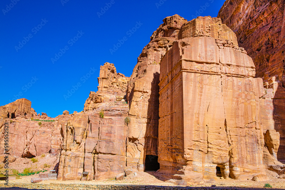 Petra ancient Nabatean archaeological park. Carved buildings in the mountains and blue bright sky, Jordan, Wadi Musa. 