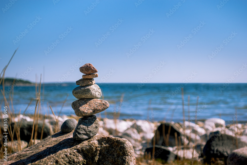 Stones stacked in harmony on beach for meditation, zen, tranquility, and work-life balance concept Stones stacked in harmony on beach for meditation, zen, tranquility, and work-life balance concept