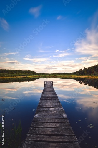 Beautiful summer afternoon landscape by the lake. Charming wooden pier over a small lake in Michala Gora, Poland.