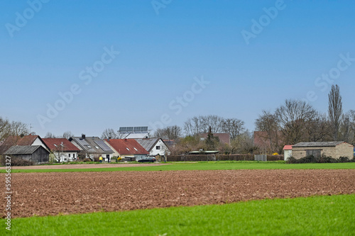 Blick auf das Wohngebiet von Grafenrheinfeld mit Einfamilienhäusern, Feldern und Bäumen bei blauem Himmel, Schweinfurt, Franken, Bayern, Deutschland