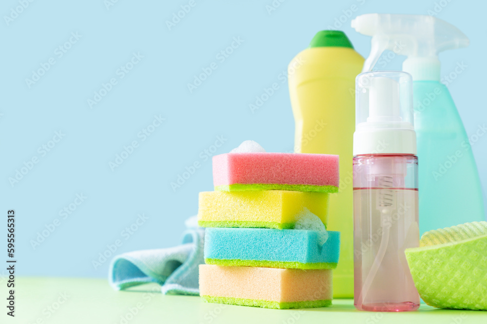 Cleaning concept - cleaning supplies on pastel yellow background Cleaning concept - cleaning supplies on pastel yellow background
