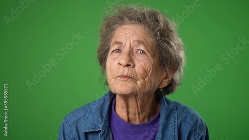 Closeup portrait of happy toothless elderly senior old woman with wrinkled skin talking isolated on green screen background.