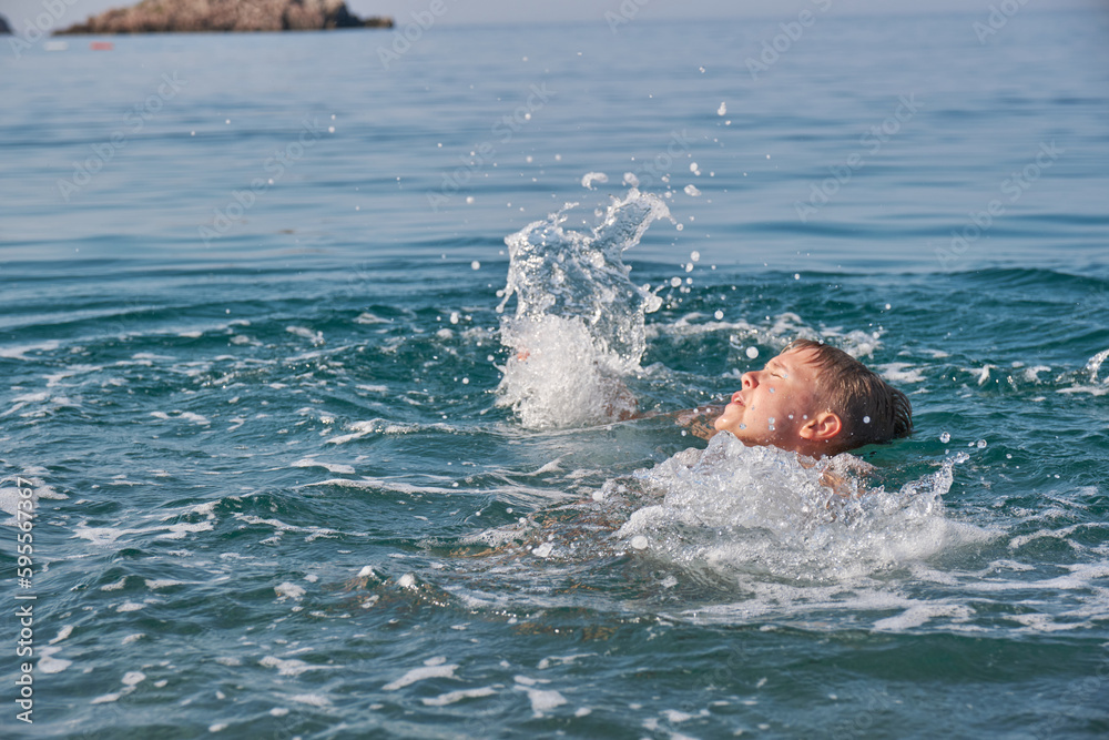 The child is drowning in the sea, screaming and waving his arms.