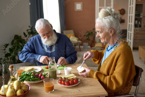 Senior family having breakfast together sitting at table in the living room at home