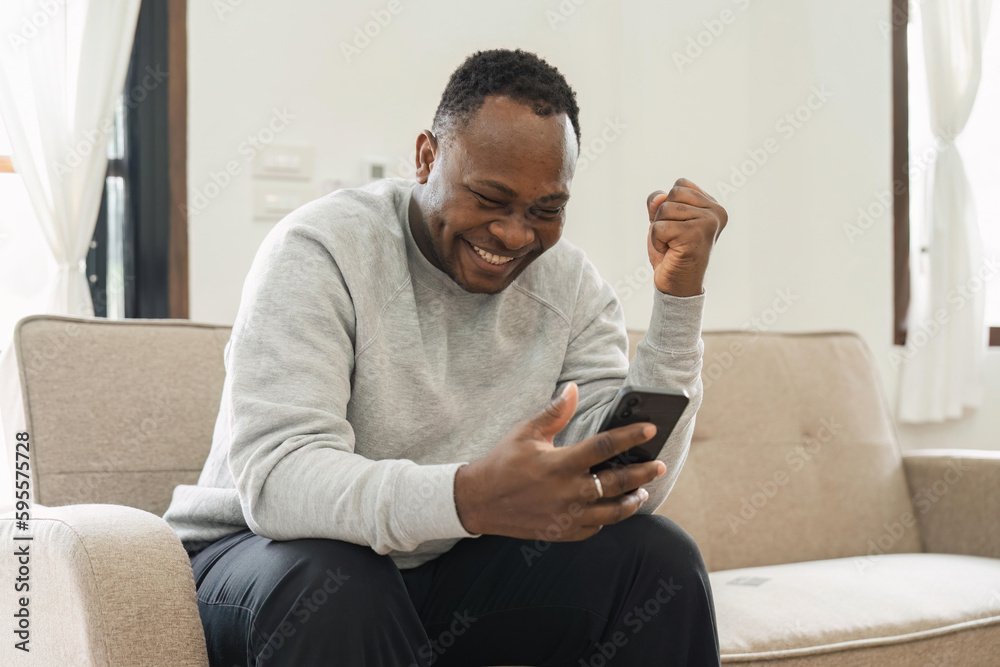 Excited happy man winner feeling joy using smartphone winning lottery game, betting, getting cashback online gift in mobile app message holding cell phone Excited happy man winner feeling joy using smartphone winning lottery game, betting, getting cashback online gift in mobile app message holding cell phone