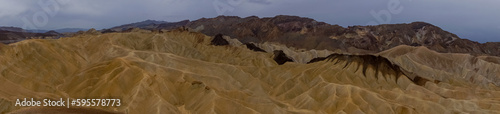 Scenic view of Badlands of Zabriskie Point, Furnace creek, Death Valley National Park, California, USA. Erosional landscape of multi hued Amargosa Chaos rock formations, Panamint Range in the back photo