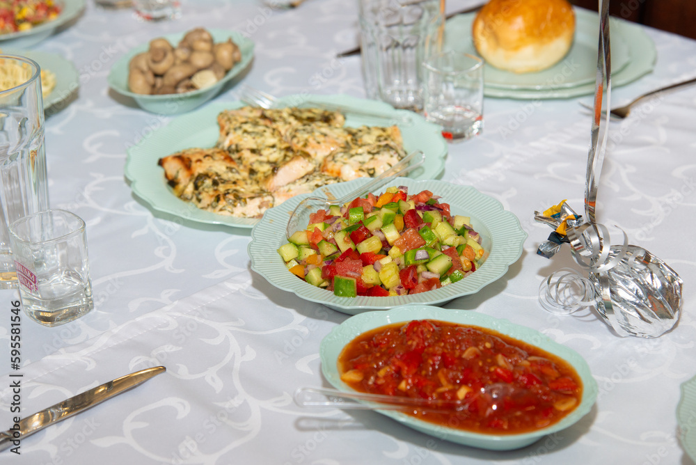 Different salads on white plates staying on banquet table. Sliced corn, tomato, pepper, cucumber, cabbage mushrooms healthy vegetarian dishes. Selective focus