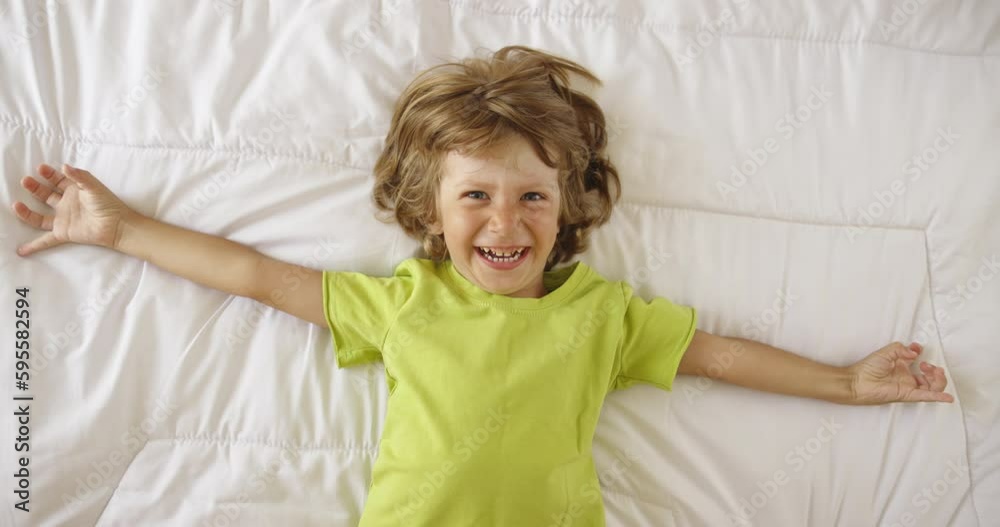 Memories of childhood with happy little dreamer boy lies on the bed Memories of childhood with happy little dreamer boy lies on the bed