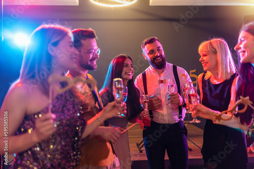Fotografija Group of friends partying in a nightclub and toasting drinks.