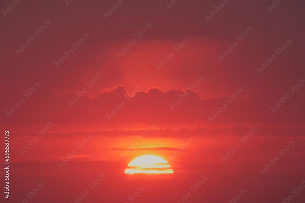 Sunset sky with red light of the setting sun. Evening clouds in the orange light of sunset rays Sunset sky with red light of the setting sun. Evening clouds in the orange light of sunset rays