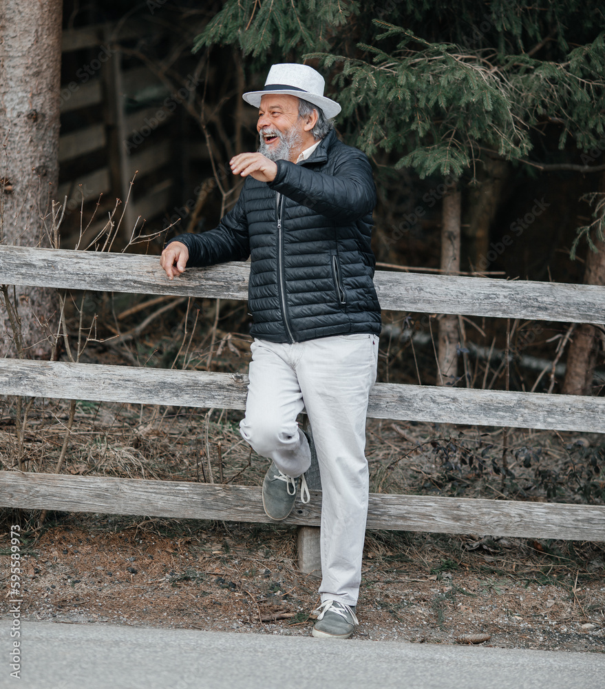 Portrait of a smiling, confident, handsome, mature man during his walk Portrait of a smiling, confident, handsome, mature man during his walk