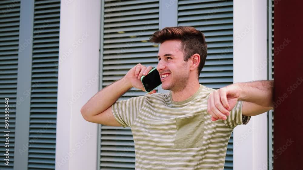 Young caucasian man talking by cellphone, smiling confident enjoying a friendly conversation leaning at the university. College guy having a mobile phone call, speaking and laughing with classmate
