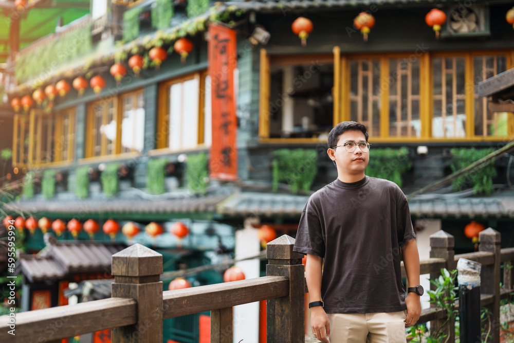 Φωτογραφία man traveler visiting in Taiwan, Tourist sightseeing in Jiufen Old Street village with Tea House background