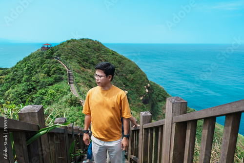 man traveler visiting in Taiwan, Tourist sightseeing in Bitou Cape Hiking Trail, New Taipei City. landmark and popular attractions near Taipei. Asia Travel concept photo