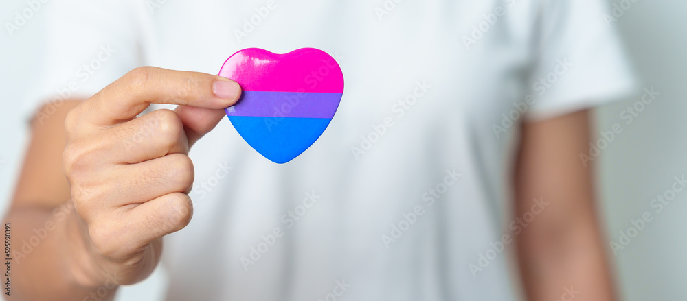 Bisexuality Celebrate Day and LGBT pride month, LGBTQ+ or LGBTQIA+ concept. Hand holding purple, pink and blue heart shape for Lesbian, Gay, Bisexual, Transgender, Queer and Pansexual community Bisexuality Celebrate Day and LGBT pride month, LGBTQ+ or LGBTQIA+ concept. Hand holding purple, pink and blue heart shape for Lesbian, Gay, Bisexual, Transgender, Queer and Pansexual community