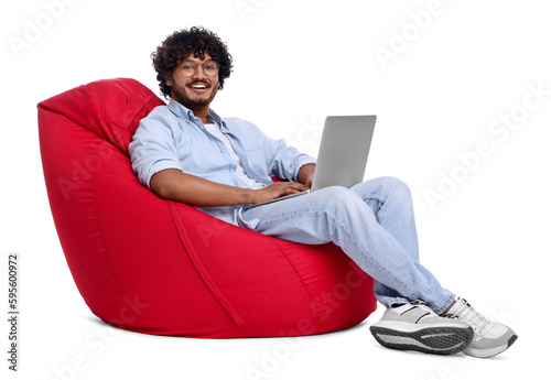 Smiling man with laptop sitting on beanbag chair against white background
