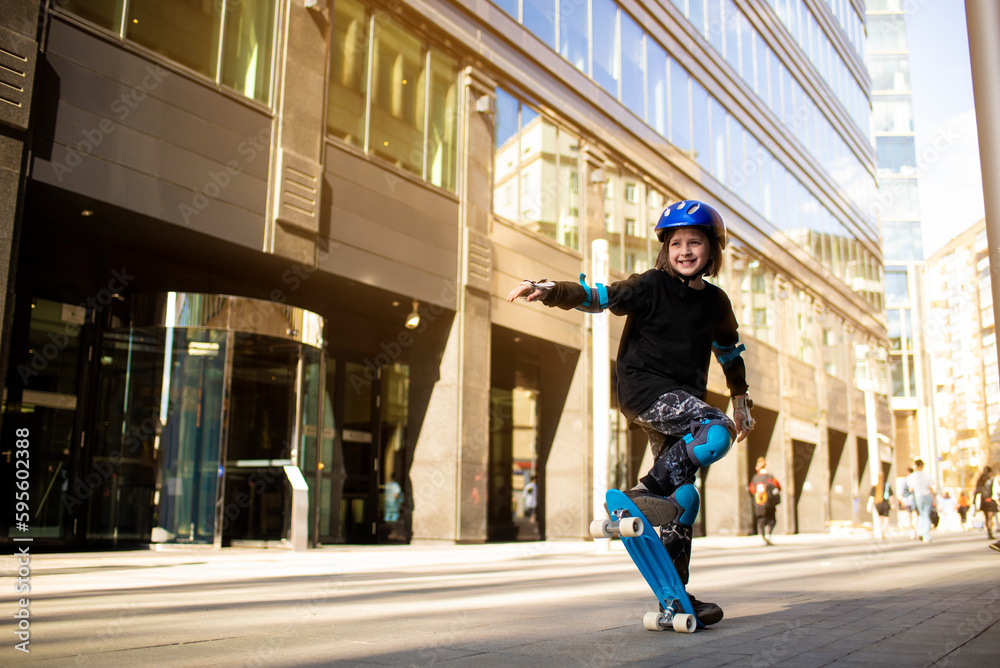  a boy in a protective helmet rides a blue city curezer, a plastic skateboard in the spring through the urban streets of the  city