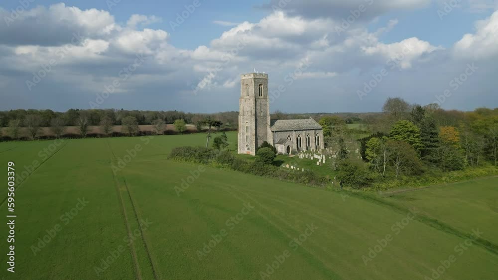Honing, Norfolk, UK – April 22 2023. Aerial push in footage towards the church of St Peter and St Paul in the village of Honing in the Norfolk countryside