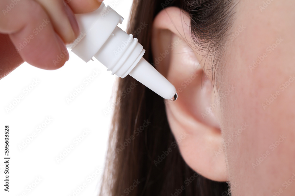 Woman using ear drops on white background, closeup Woman using ear drops on white background, closeup