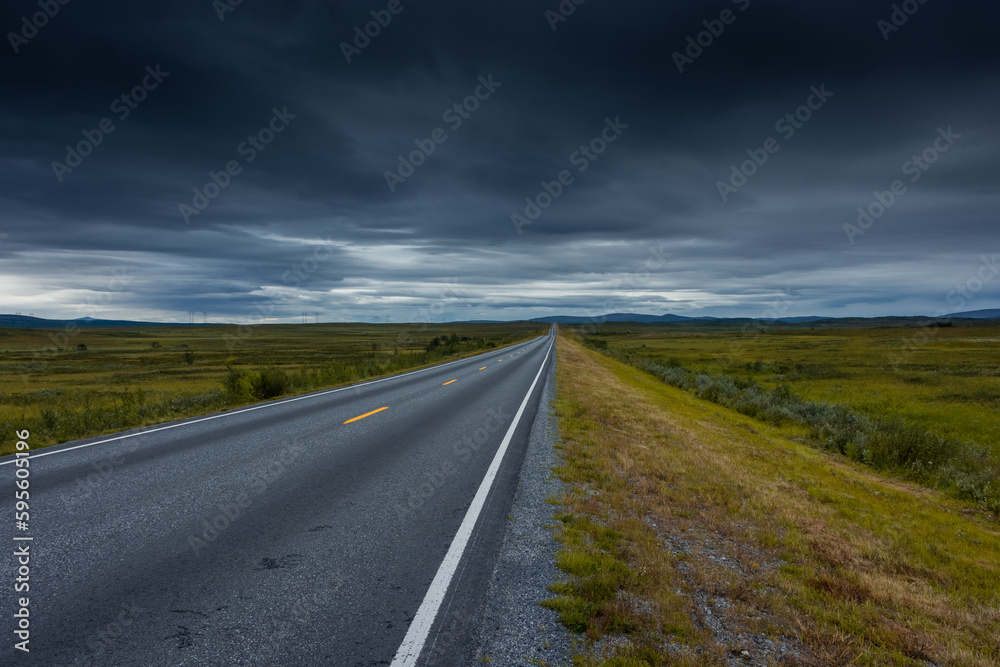 Epic cloudy landscape of an empty highway through the tundra of  Norway