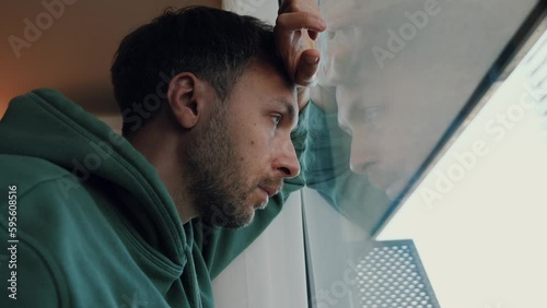 Midlife crisis in men concept. Tired depressed man portrait looking at window with frustrated eyes. Burnout, life problems and male middle age crisis.
