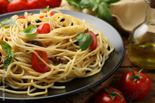 Delicious pasta with anchovies, tomatoes and olives on table, closeup