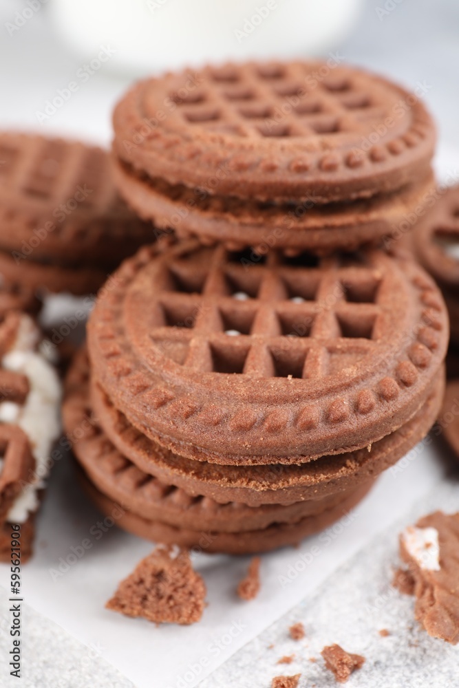 Tasty chocolate sandwich cookies with cream on light grey table, closeup