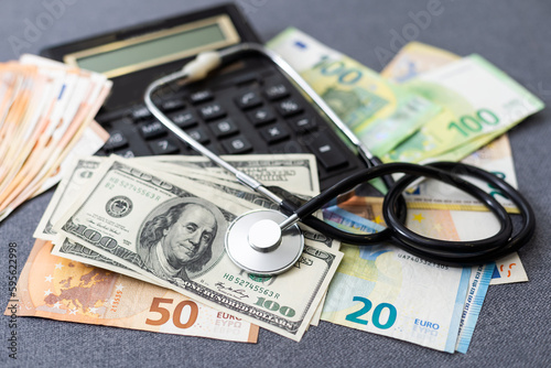 Stethoscope - photo on money bank notes. Medical stethoscope is laying on money bank notes. Dollar and Euro banknotes as background for doctor gadget. Financial health concept. Expensive medicine.