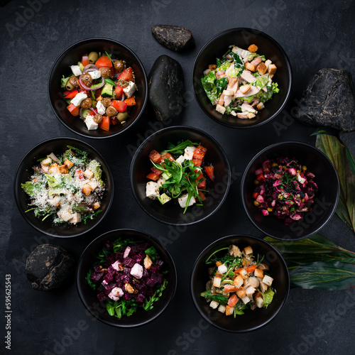 Set of vinaigrette salad, Caesar salad, Greek salad, salad with chicken, beans, croutons and salad with boiled beets, feta cheese and walnuts.