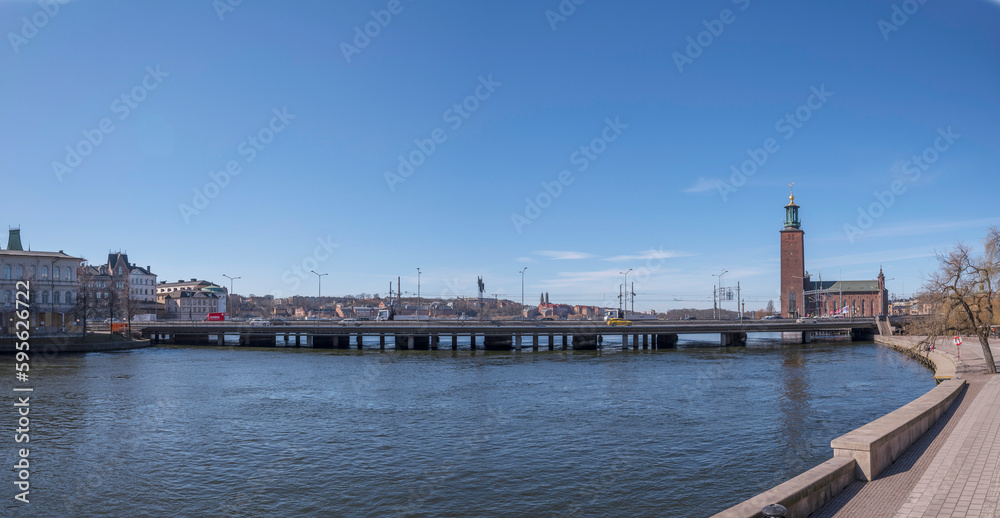 Pier, train and high way bridges at the stream Strömmen with the Town City Hall, a sunny spring day in Stockholm Pier, train and high way bridges at the stream Strömmen with the Town City Hall, a sunny spring day in Stockholm