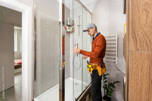Plumber installing a shower cabin in bathroom