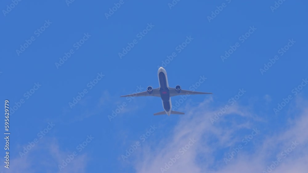 Airplane Air Canada passing overhead near the airport. Air passenger plane bottom view while flying. Jet aircraft departure climb in the blue sky Airplane Air Canada passing overhead near the airport. Air passenger plane bottom view while flying. Jet aircraft departure climb in the blue sky
