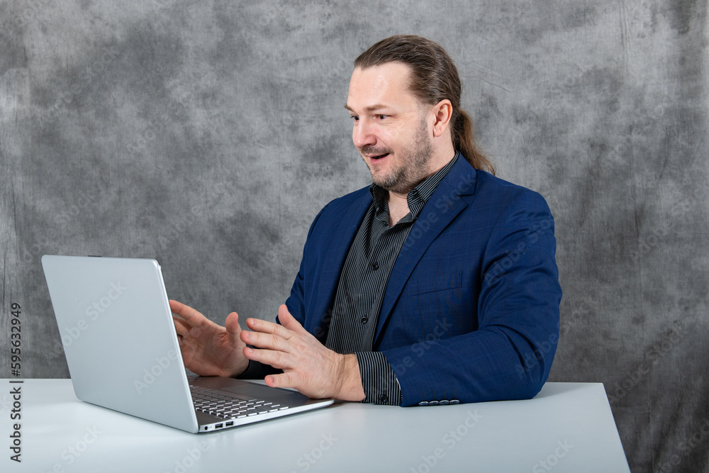 Surprised businessman working on a laptop in a blue suit Surprised businessman working on a laptop in a blue suit