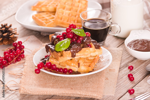 Waffles with chocolate topping and red currant.
