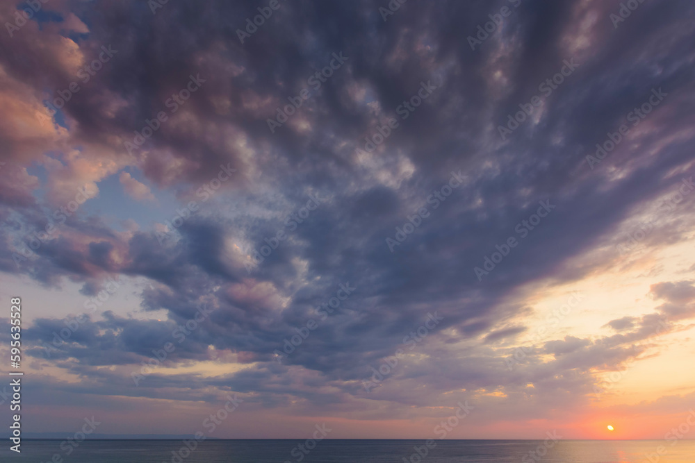 dramatic dawn at the sea. gray clouds on the sky with red sun above the horizon. summer holidays rainy weather forecast dramatic dawn at the sea. gray clouds on the sky with red sun above the horizon. summer holidays rainy weather forecast