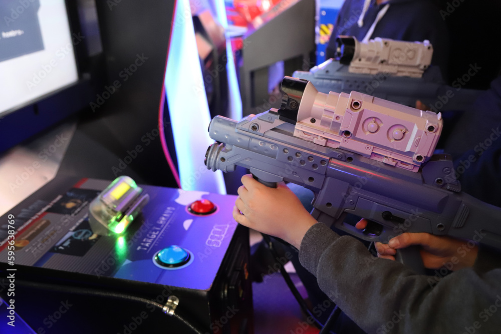 Arcade game room. Video game park for children and teenagers. Boy playing in Sega Target Bravo