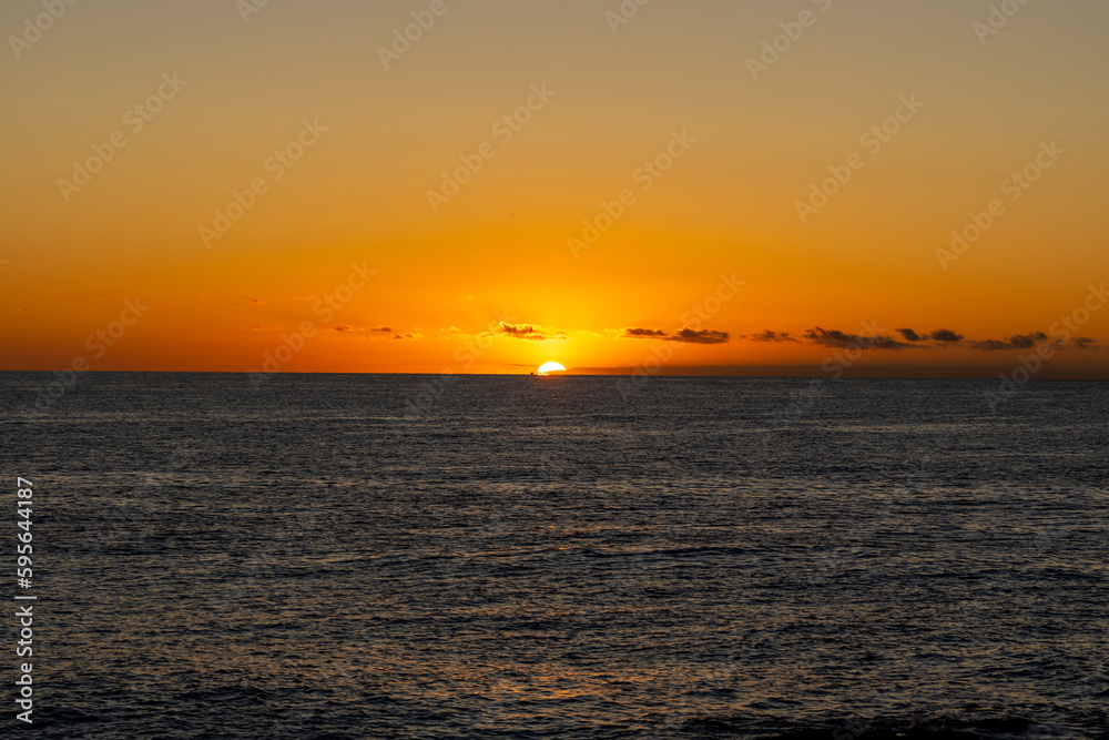 Beautiful, red orange dawn on the mediterranean sea. The rays of the sun through the fog. The blue sky over the mediterranean sea, the morning comes, the sun is reflected in the water.