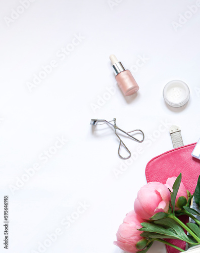 Beauty lifestyle concept frame on the white background with cosmetics and peony flowers. Top view. Copy space