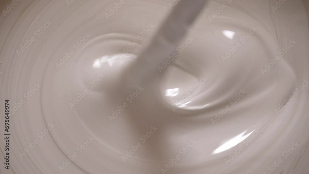 mixing white paint in a bucket mixing white paint in a bucket
