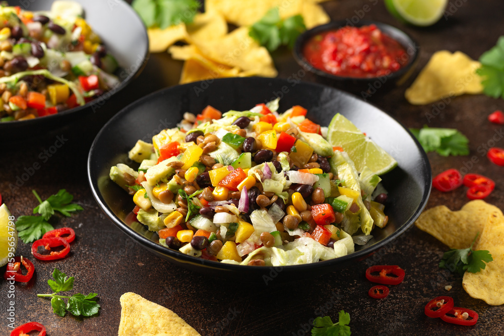 Mexican style salad of black beans, lentils, corn, tomato and lettuce with a salsa and tortilla chips Mexican style salad of black beans, lentils, corn, tomato and lettuce with a salsa and tortilla chips