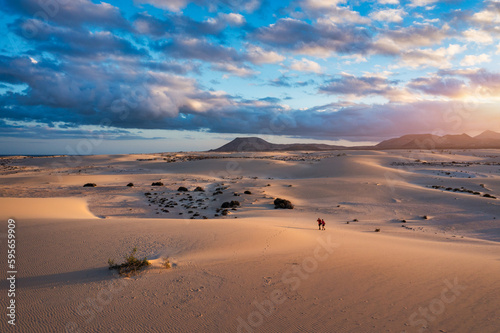 Sand dunes in Las Dunas de Corralejo, Corralejo Natural Park, dramatic cloud formation, Fuerteventura, Canary Islands, Spain. Sand dunes landscape, Corralejo, Fuerteventura, Canary Islands, Spain.