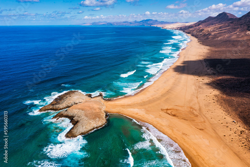 Amazing Cofete beach with endless horizon. Volcanic hills in the background and Atlantic Ocean. Cofete beach, Fuerteventura, Canary Islands, Spain. Playa de Cofete, Fuerteventura, Canary Islands. photo
