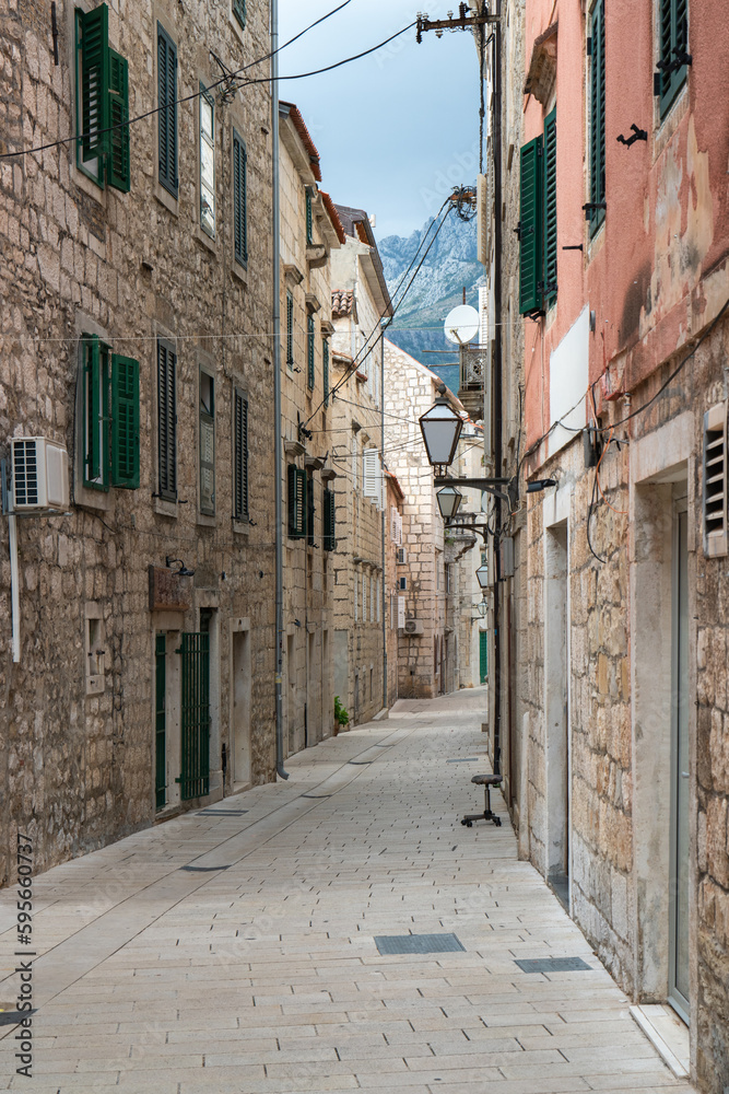narrow street in Makarska city, Dalmatia, Croatia. Hikers. A popular tourist destination for summer holidays in Croatia.