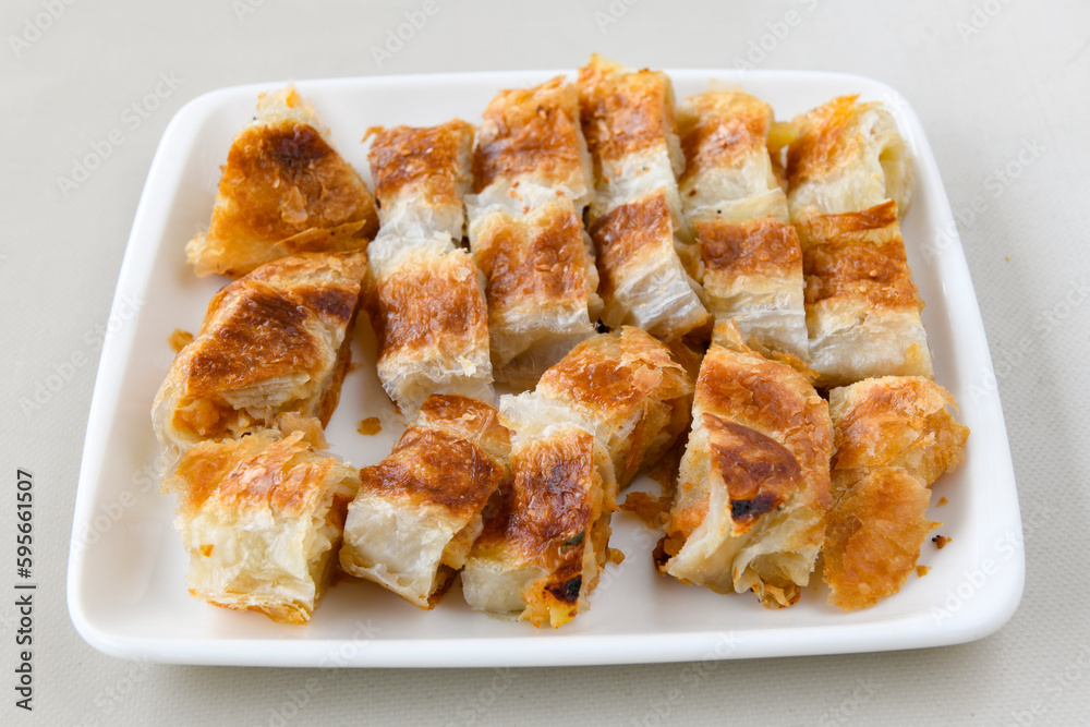 Turkish style meat stuffed filo dough borek served kol boregi. Cheese and minced pie are sliced on a marble background. Turkish name: Kol Boregi, ispanakli, kiymali, Su Boregi Turkish style meat stuffed filo dough borek served kol boregi. Cheese and minced pie are sliced on a marble background. Turkish name: Kol Boregi, ispanakli, kiymali, Su Boregi