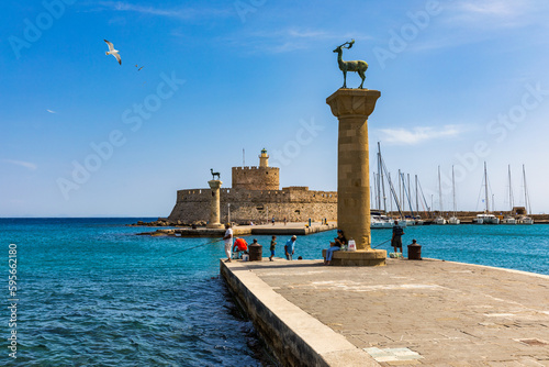 Mandraki port with deers statue, where The Colossus was standing and fort of St. Nicholas. Rhodes, Greece. Hirschkuh statue in the place of the Colossus of Rhodes, Rhodes, Greece