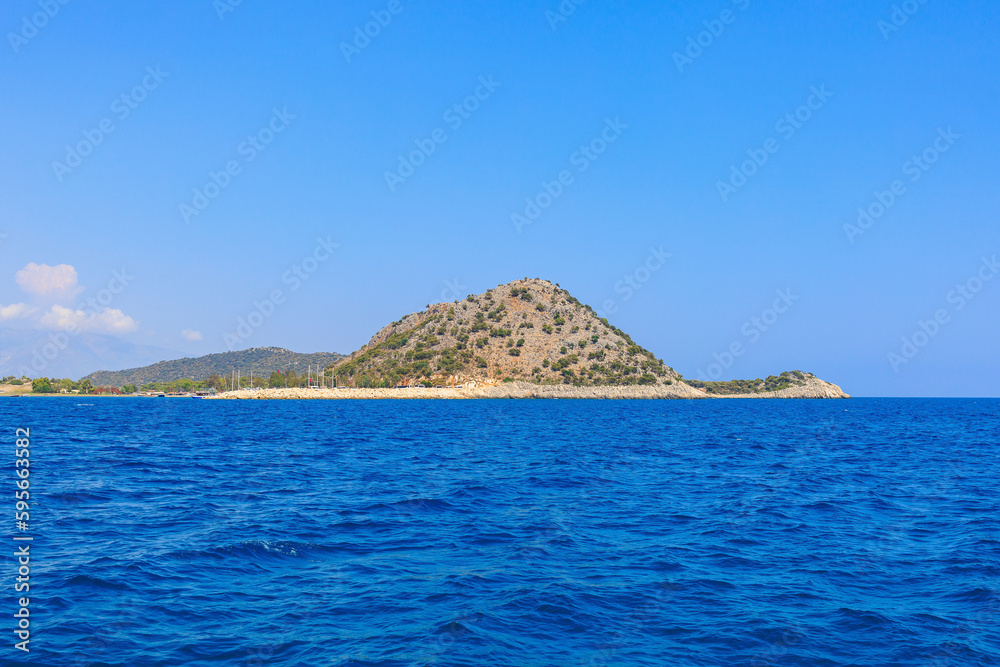 View of the rocky shore from the sea. Mediterranean Sea in Turkey. Popular tourist places. Background View of the rocky shore from the sea. Mediterranean Sea in Turkey. Popular tourist places. Background