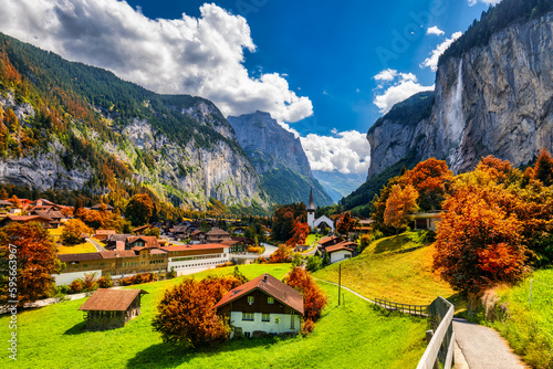 Captivating autumn view of Lauterbrunnen valley with gorgeous Staubbach waterfall and Swiss Alps at sunset time. Lauterbrunnen village with autumn red foliage, Berner Oberland, Switzerland, Europe. photo