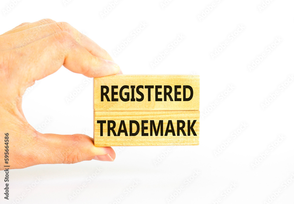 Registered trademark symbol. Concept word Registered trademark on wooden blocks. Beautiful white table white background. Businessman hand. Business and registered trademark concept. Copy space. Registered trademark symbol. Concept word Registered trademark on wooden blocks. Beautiful white table white background. Businessman hand. Business and registered trademark concept. Copy space.