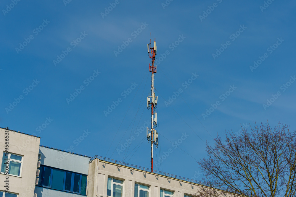 Obraz premium New GSM antennas on the roof of a residential building in the city for transmitting a 5g signal are a danger to human health. Radiation pollution of the environment through cell towers.